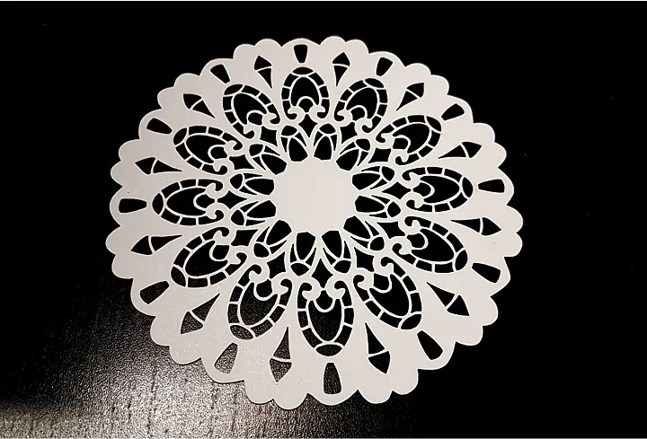 Intricate circular laser cut paper art design with detailed floral and geometric patterns